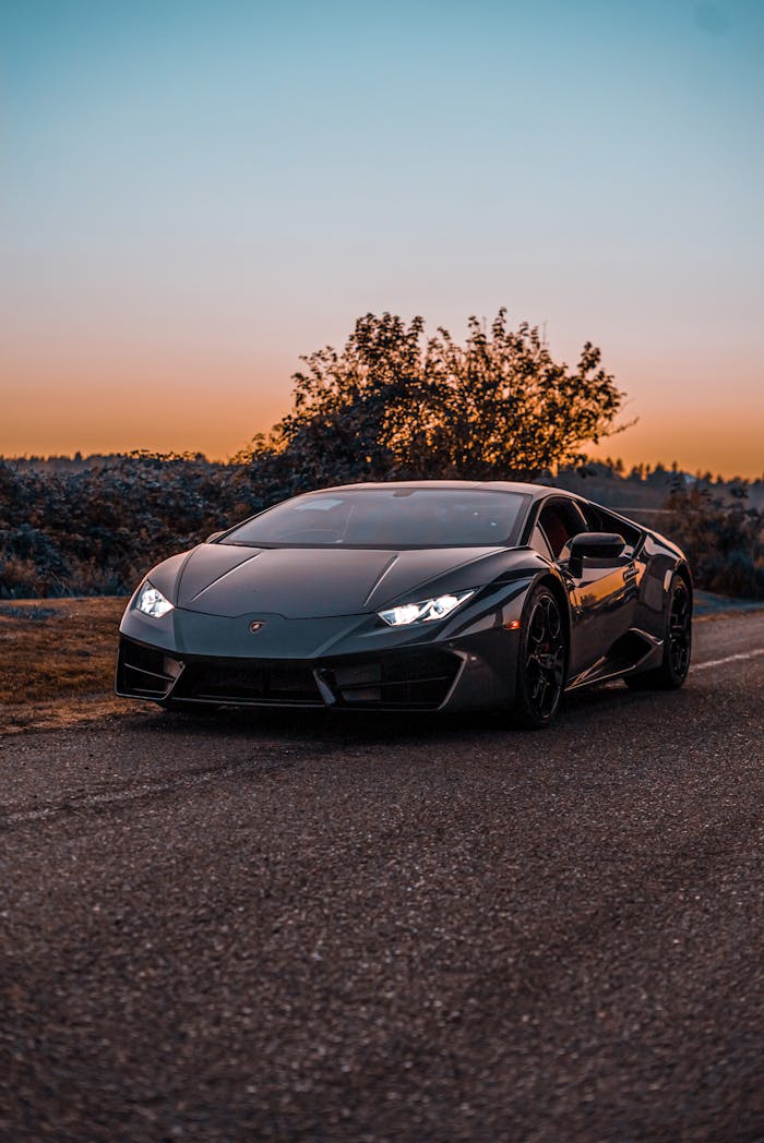 Lamborghini Huracan supercar parked on a scenic road during sunset.
