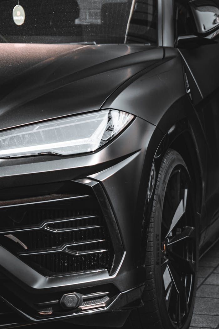 Close-up view of a black Lamborghini Urus SUV parked, showcasing its sleek design.