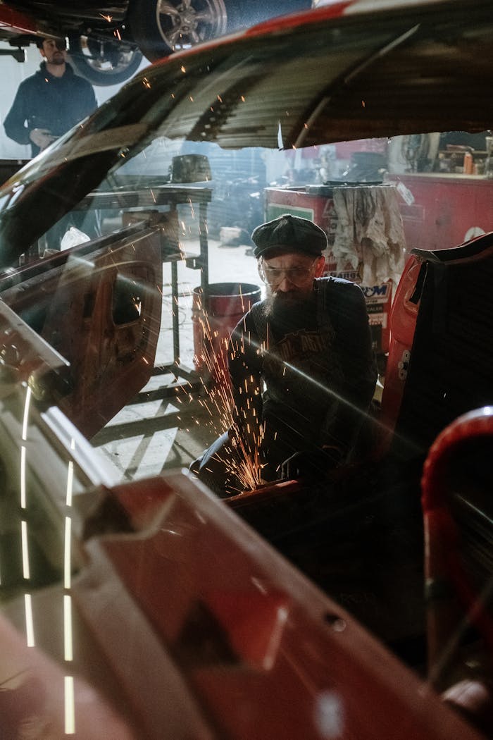 A mechanic diligently works on car repairs in a busy auto garage setting.